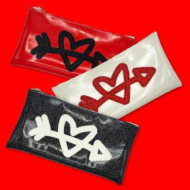 red, black and white heart and arrow clutches on a red background